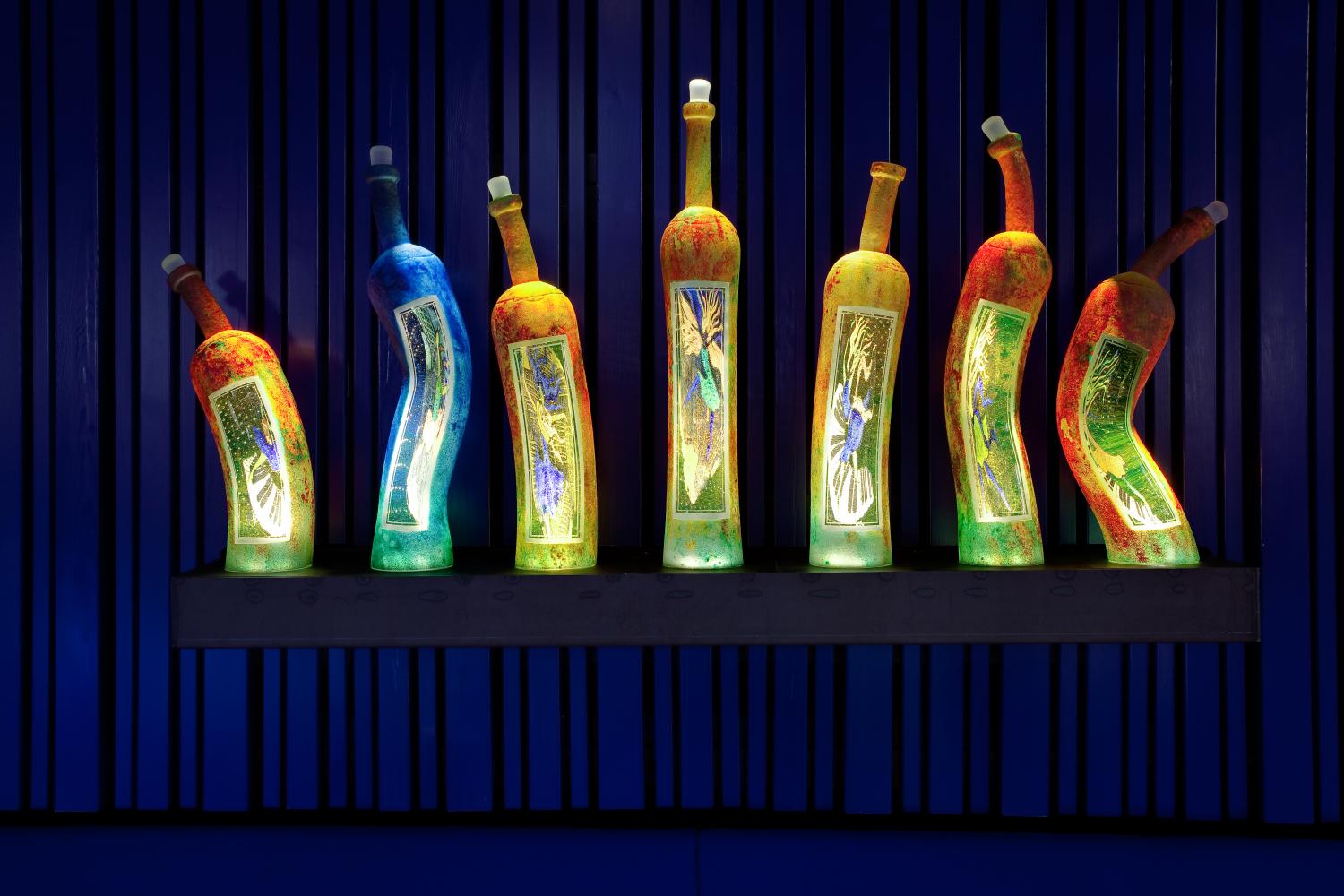 Olika glasflaskor som representerar veckans dagar