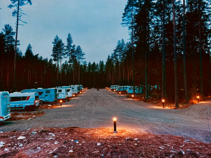 Kvällsbild över Safariparkens ställplats med lysande lampor